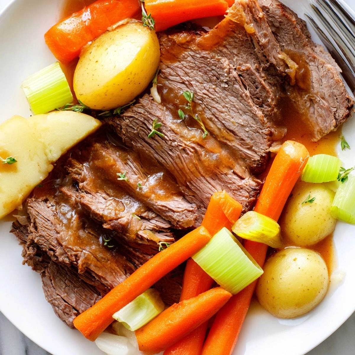 Fork-tender Pot Roast, glistening with savory gravy and surrounded by colorful vegetables.